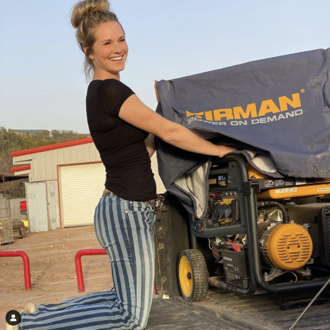 An image of a woman uncovering her FIRMAN Generator that is on her truck bed.