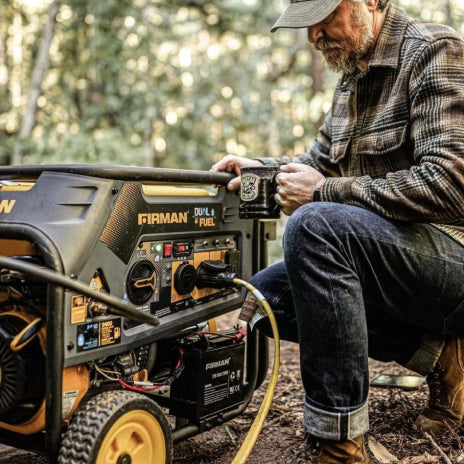 Image of a man holding a cup of coffee in the woods with a FIRMAN Power Generator that is connected to a power cord.