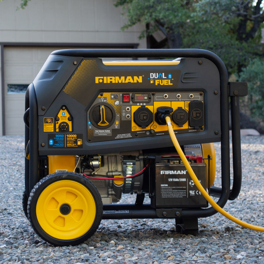 A FIRMAN Power Equipment Dual Fuel Portable Generator 8000W Electric Start 120/240V with a yellow and black color scheme, situated on a gravel surface, connected to a yellow power cord.