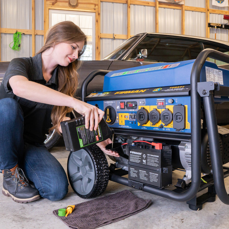 A woman in a garage placing a FIRMAN Power Equipment Tri Fuel Portable Generator 11600W Electric Start 120V/240V with CO alert into a portable standby generator beside a classic car.