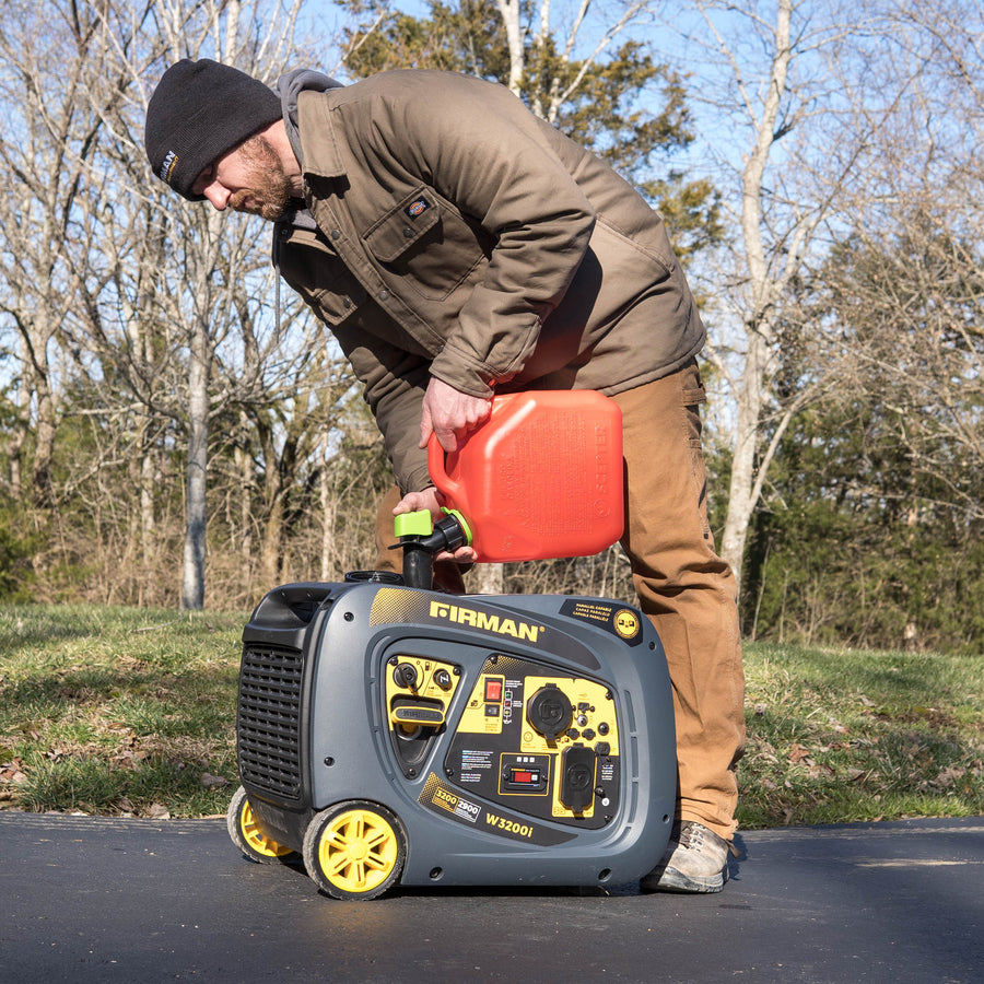A man in winter clothing refuels a FIRMAN Power Equipment Refurbished Gas Inverter 3200W Recoil Start portable generator outside on a sunny day.