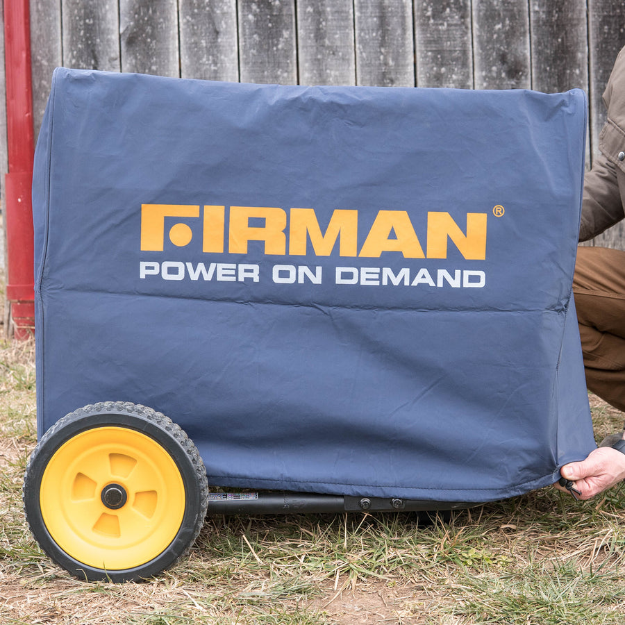 A person partially visible holding a FIRMAN Power Equipment Large Size Portable Generator Cover over a generator with visible yellow wheels, against a red wooden backdrop.