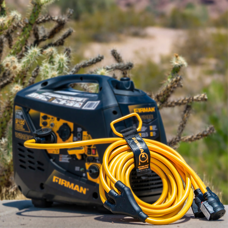 A FIRMAN Power Equipment 25' Heavy Duty L5-30P to (3) 5-20R Power Cord With Storage Strap is coiled in front of a portable generator outdoors, ensuring reliable power in any setting. Desert plants blur into the background.