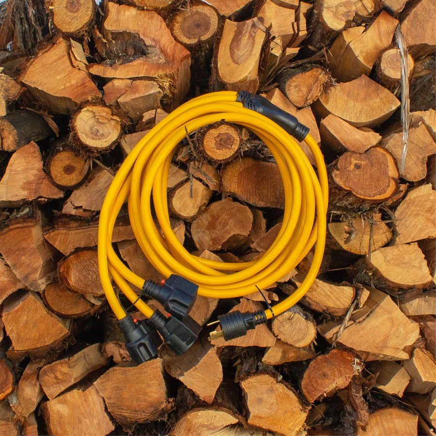 A FIRMAN Power Equipment 25' Heavy Duty L5-30P to (3) 5-20R Power Cord with storage strap is coiled on top of stacked firewood.