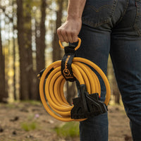 A person standing in a forest holding a FIRMAN Power Equipment 25' Heavy Duty L14-30P to (4) 5-20R Power Cord With Storage Strap.