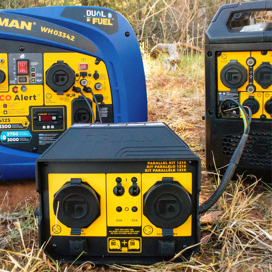 Three FIRMAN Power Equipment 50A Portable Generator Parallel Kits connect RV-ready inverter generators outdoors on dry grass, with power cables linking the units.