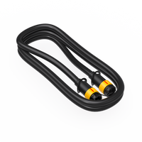 A coiled black cable with two yellow and black connectors on each end, the FIRMAN Power Equipment Parallel Cord for over 5000W Portable Inverter Generator is placed on a white surface, ready to double your power with compatibility for FIRMAN Whisper Series inverters.