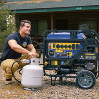 A man is connecting a propane tank to a FIRMAN Power Equipment TRI FUEL PORTABLE GENERATOR 15000W ELECTRIC START 120/240V WITH CO ALERT outdoors in front of a log cabin. This reliable generator features an impressive 15000-watt capacity and includes the CO Alert feature for added safety.