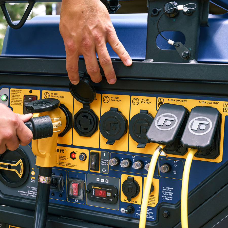 A person plugs a yellow power cable into the blue and yellow generator control panel, featuring various switches, sockets, and meters on the robust 15000-watt TRI FUEL PORTABLE GENERATOR 15000W ELECTRIC START 120/240V WITH CO ALERT by FIRMAN Power Equipment.