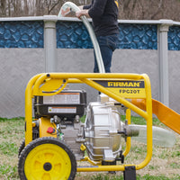 A person uses a yellow FIRMAN Power Equipment 2-Inch Portable High Pressure Water and Semi-Trash Pump with a hose to drain or fill an above-ground pool outdoors.