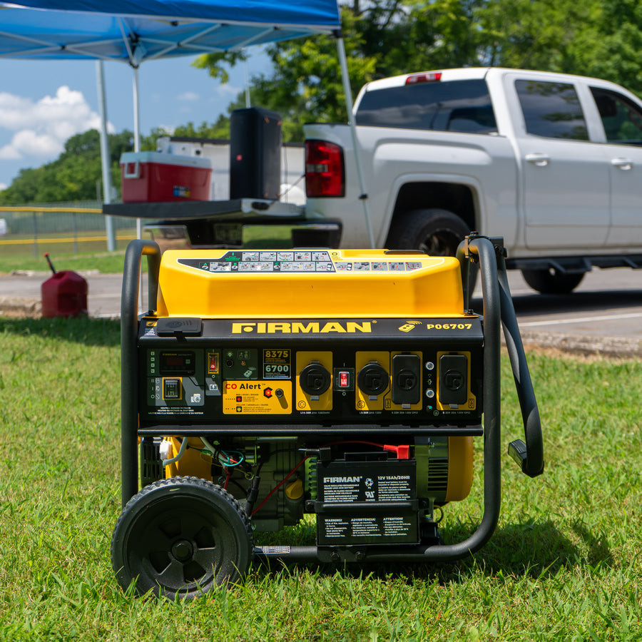 A yellow FIRMAN Power Equipment GAS PORTABLE GENERATOR 8375W REMOTE START 120/240V sits on grass, with a white pickup truck and blue canopy in the background on a sunny day.