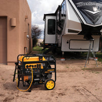 A FIRMAN Power Equipment Gas Portable Generator 15000W Electric Start 120/240V with CO Alert operating next to a parked RV in a sandy area with a sparse grassy background and an adobe-style building.