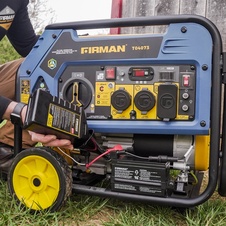 A person outdoors connects a battery to a FIRMAN Power Equipment Tri Fuel Portable Generator 4000W Electric Start 120/240V with CO ALERT, displaying various outlets and control buttons.