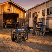 A person stands outside a camper by an open cooler, with a FIRMAN Power Equipment T06373 Tri Fuel Portable Generator 7850/6300W Electric Start Gas CO Alert on the ground and a wooden garage in the background.