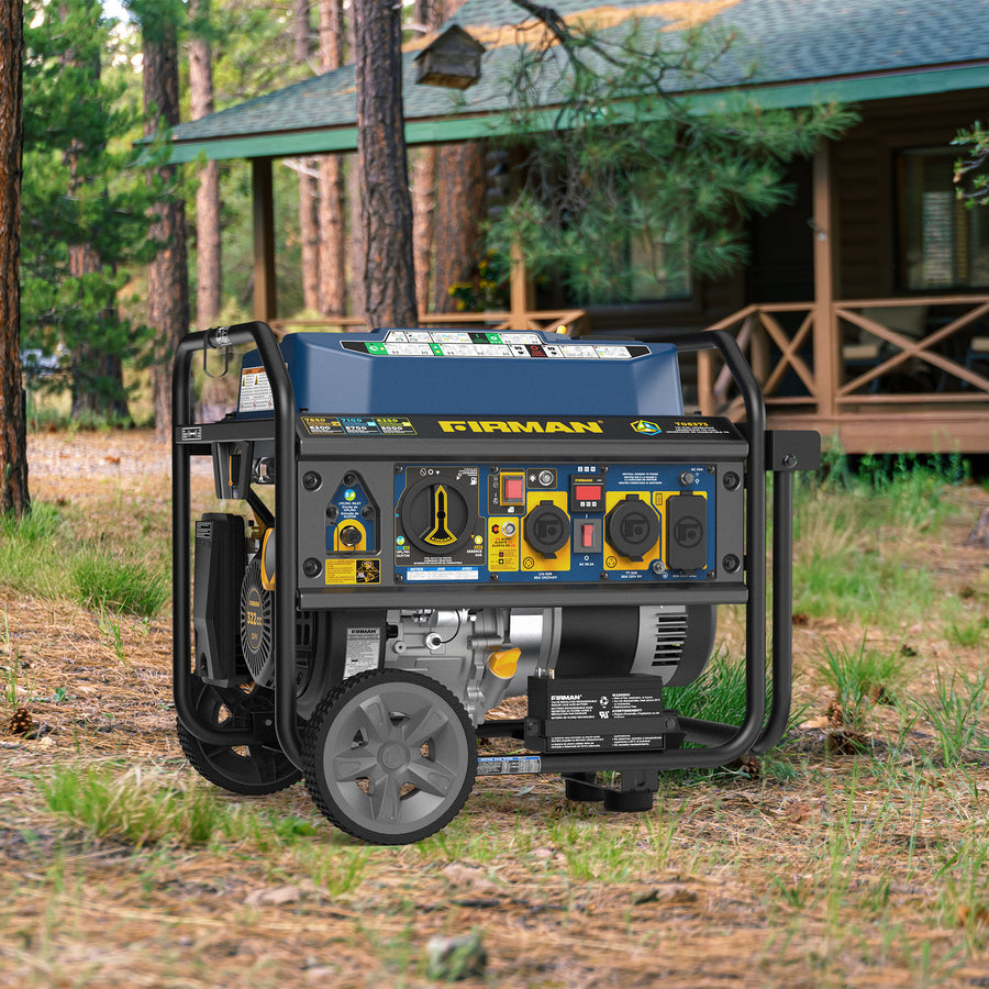A FIRMAN Power Equipment Tri Fuel Portable Generator 7850/6300W Electric Start Gas CO Alert is set up outdoors on grass near a cabin with trees and a porch in the background, ready to provide portable whole home power.