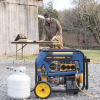 A man using a circular saw on a wooden plank next to a FIRMAN Power Equipment Refurbished Tri Fuel Portable Generator 7500W Electric Start 120/240V and a propane tank outside a barn.