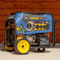 The FIRMAN Power Equipment Tri Fuel 7500W Portable Generator Electric Start 120/240V, with control panel, power outlets, wheels, and battery, is ideal as a home backup generator and shown outdoors against a wooden wall.
