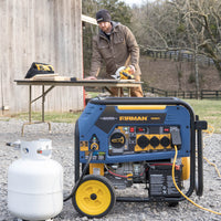 A FIRMAN Power Equipment Tri Fuel 7500W Portable Generator Electric Start 120/240V, connected to a propane tank, sits outdoors on gravel while a man works nearby—showcasing dependable home backup power.