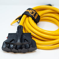 Yellow Firman Power Equipment extension cord wrapped neatly with a black velcro tie, featuring a multi-outlet power connector at the end.