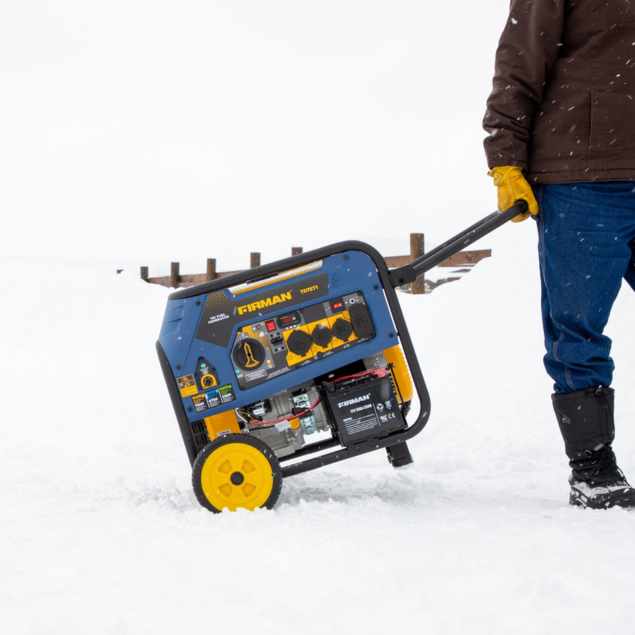 A person pulls a FIRMAN Power Equipment Refurbished Tri Fuel Portable Generator 7500W Electric Start 120/240V over a snowy surface.