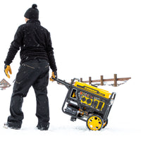 A person in winter clothing operates a yellow and black FIRMAN Power Equipment Inverter Open Frame Portable Generator 4500W Remote Start with CO Alert on wheels in a snowy environment.