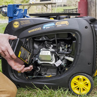 A person inserting a battery into a FIRMAN Power Equipment Dual Fuel Inverter Portable Generator 4000W Electric Start with CO ALERT with visible pricing and capacity label.